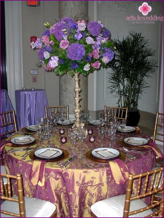 Gyönyörű lila csokor az esküvői asztalnál