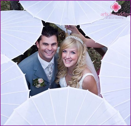 Bride and groom surrounded by umbrellas