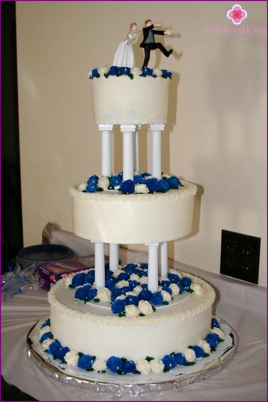 White and blue cake with newlywed figures