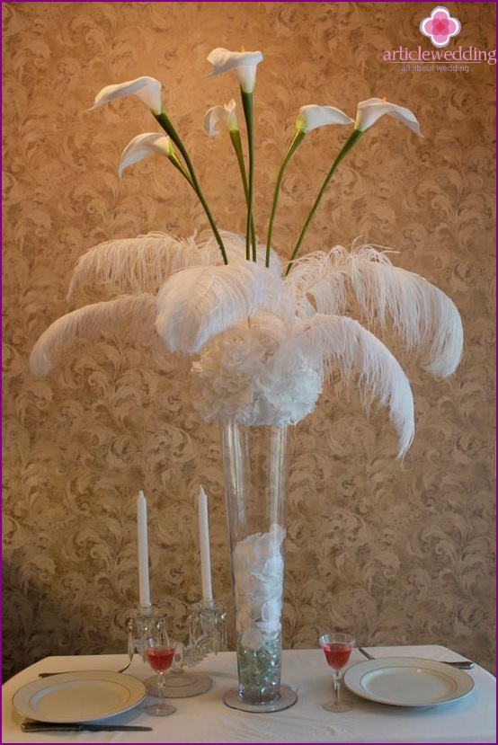 Table decoration with flowers and feathers.