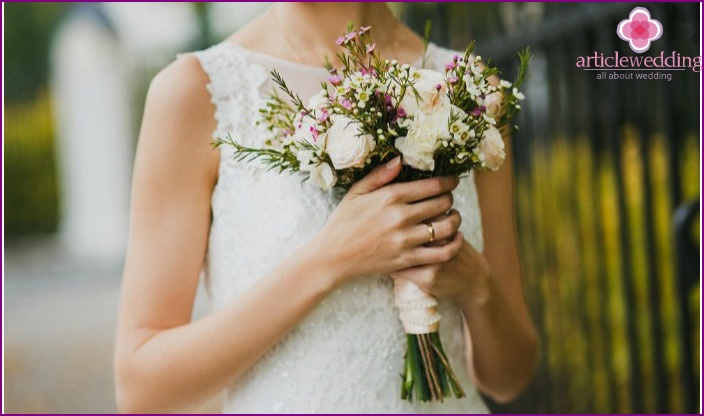 Braut mit einem zarten Blumenstrauß