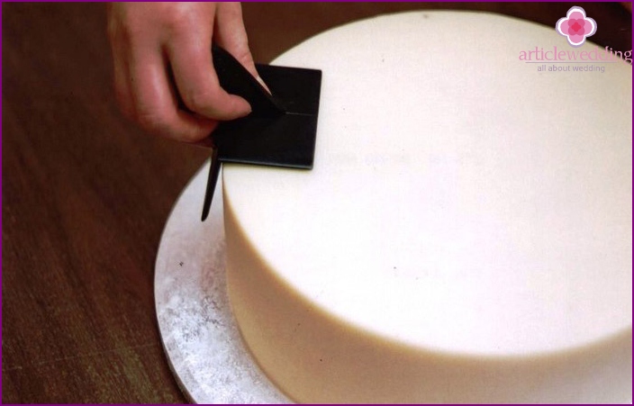 Smoothing mastic on the cake